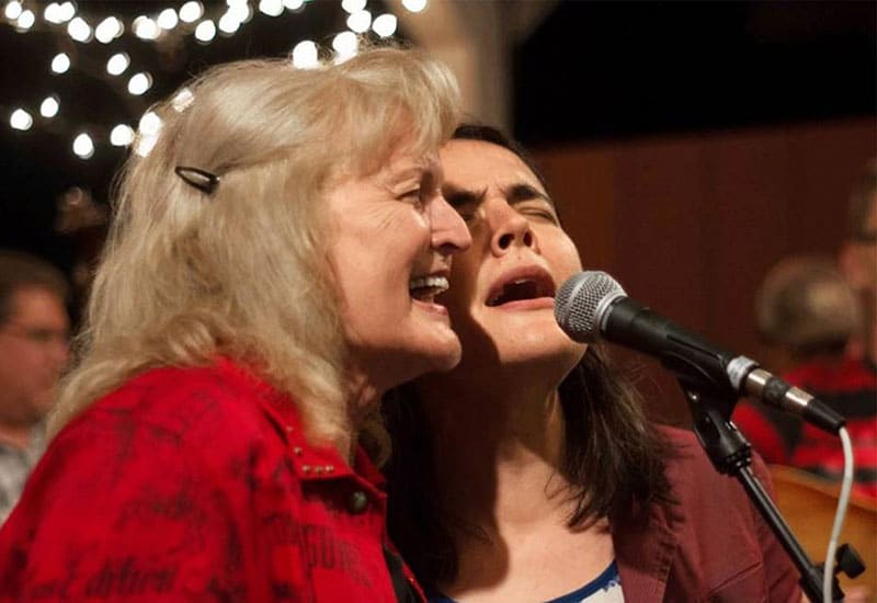 Two women singing at a concert
