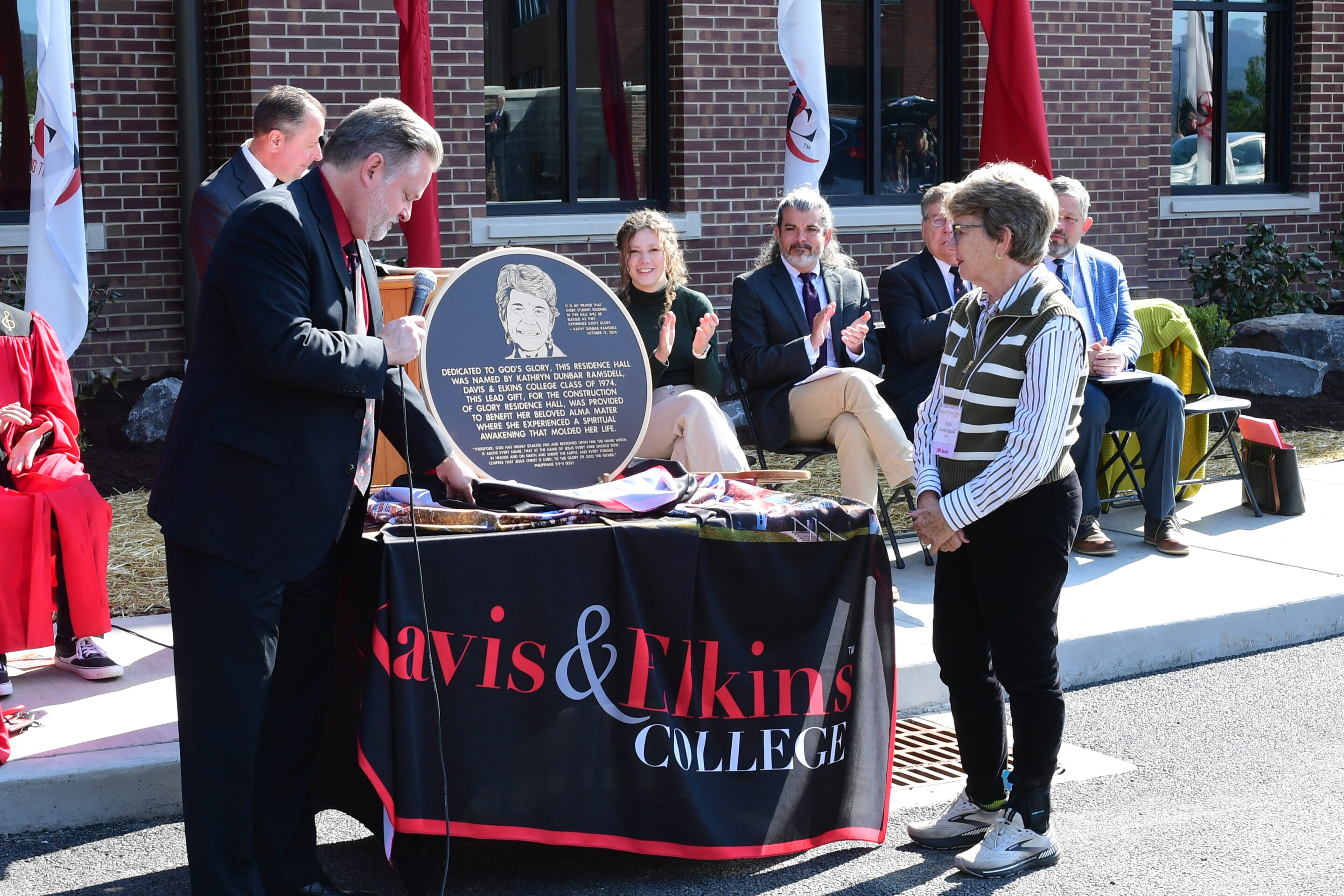President Wood presents a dedication plaque to Kathryn Ramsdell for her generosity in funding the construction of Glory Residence Hall at the dedication ceremony in October 2024.