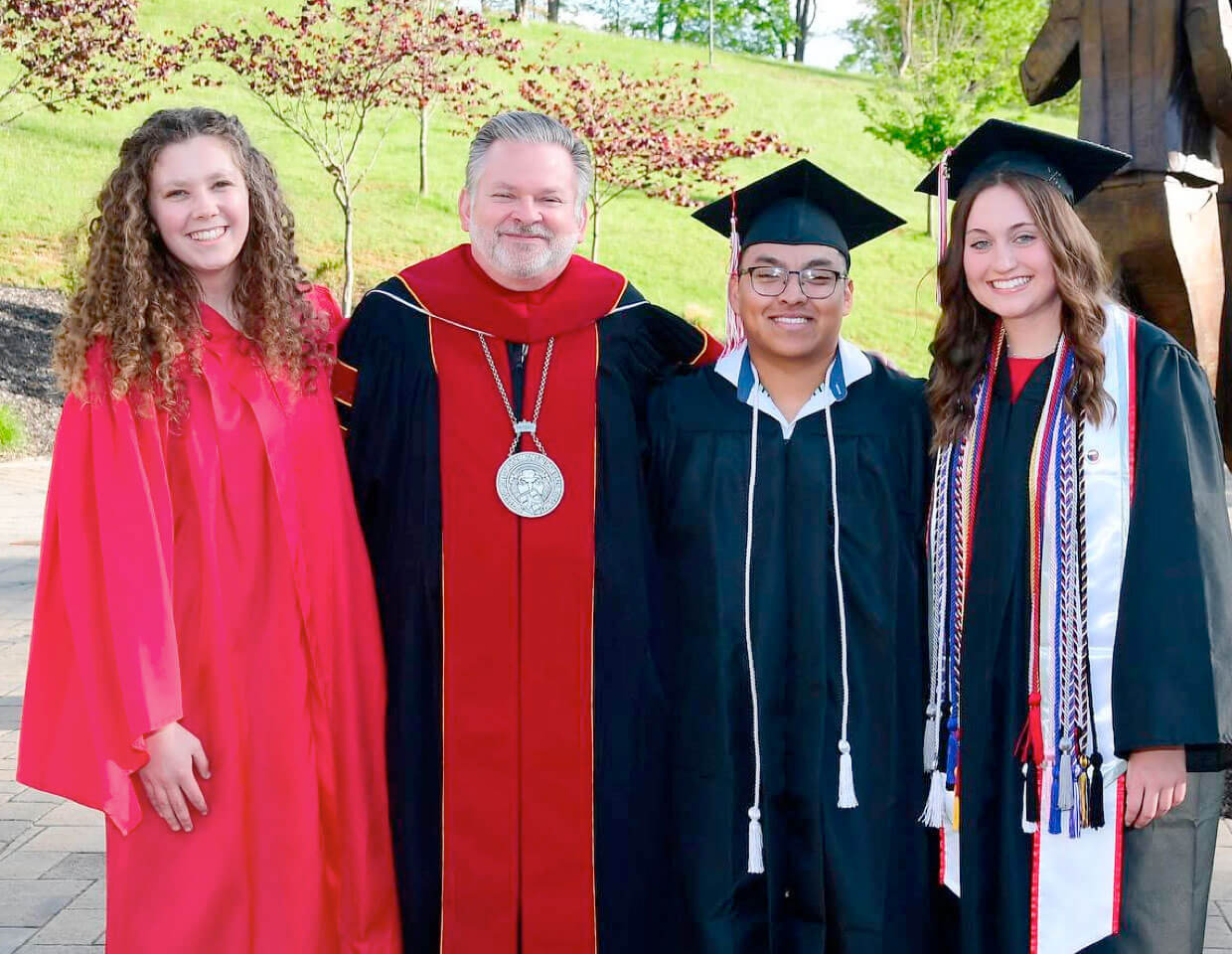 President Chris Wood with three brand new alumni.